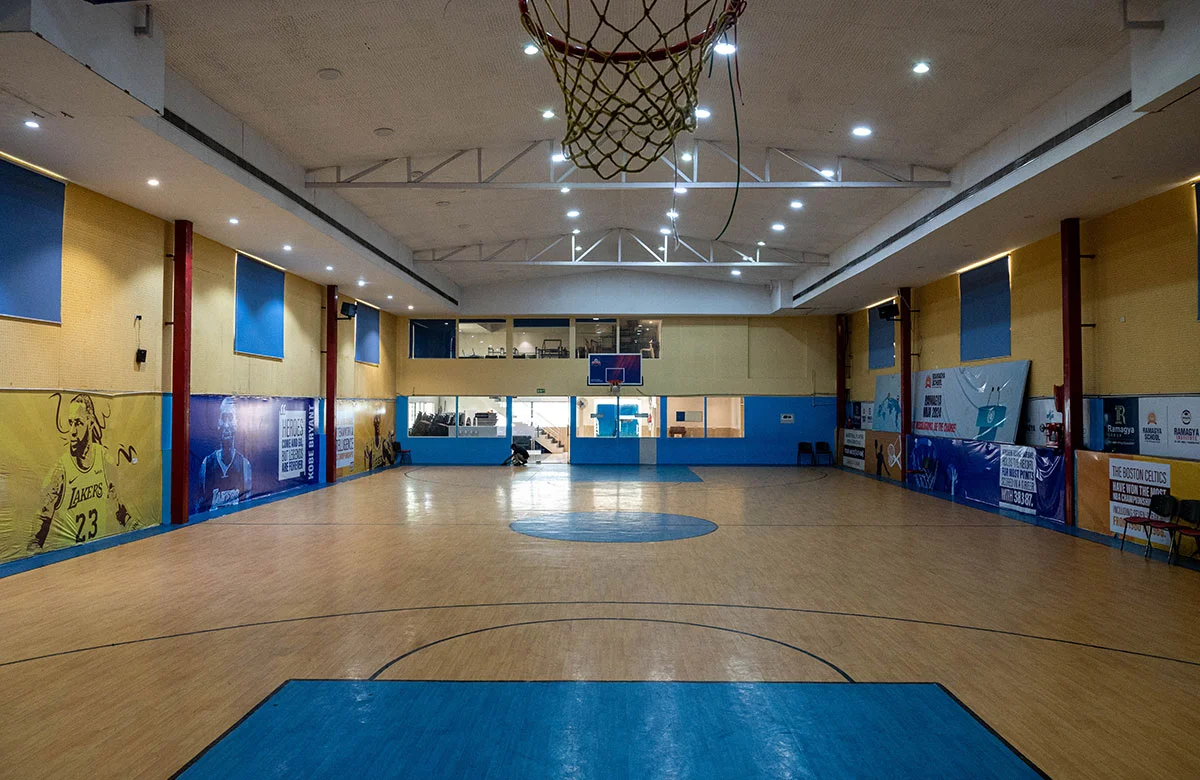 Basketball player mid-air during a dunk with stadium lights in background